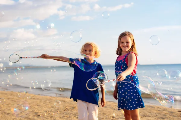 Los niños soplan burbujas en la playa. Niño con burbujas — Foto de Stock