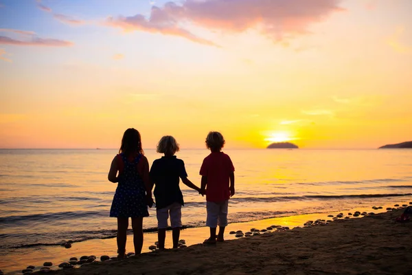 孩子们在海边玩耍。孩子在日落海. — 图库照片