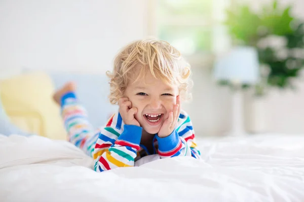 Niño jugando en la cama. Habitación de niños. Niño en casa . —  Fotos de Stock