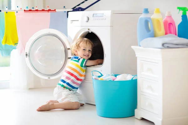 Child in laundry room with washing machine — Stock Photo, Image