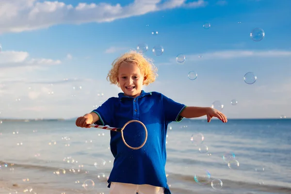 I bambini soffiano bolle in spiaggia. Bambino con bolle — Foto Stock