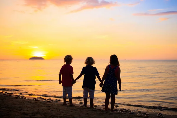 Enfant jouant sur la plage océanique. Enfant au coucher du soleil mer . — Photo