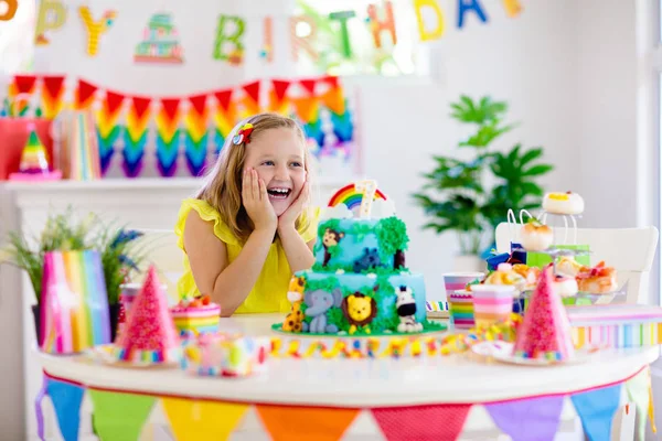 Fiesta de cumpleaños infantil. Los niños soplan vela en la torta . — Foto de Stock