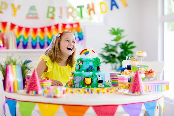 Fiesta de cumpleaños infantil. Los niños soplan vela en la torta . —  Fotos de Stock