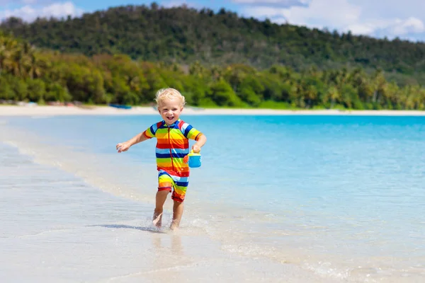 As crianças brincam na praia tropical. Brinquedo de areia e água . — Fotografia de Stock