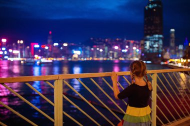 Çocuklar Hong Kong liman siluetini izliyor. 