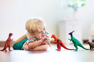 Oyuncak dinozorlar ile oynayan çocuk. Çocuklar oyuncak.