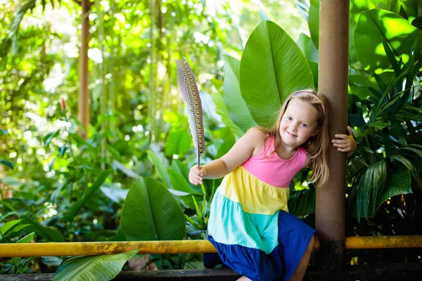 Niño jugando con plumas de pájaro. Niño en el zoológico . —  Fotos de Stock