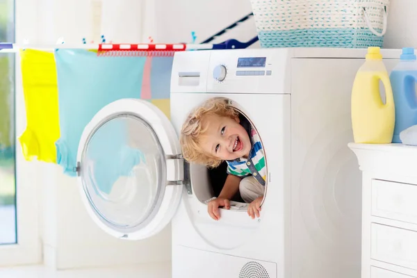 Niño en lavadero con lavadora —  Fotos de Stock