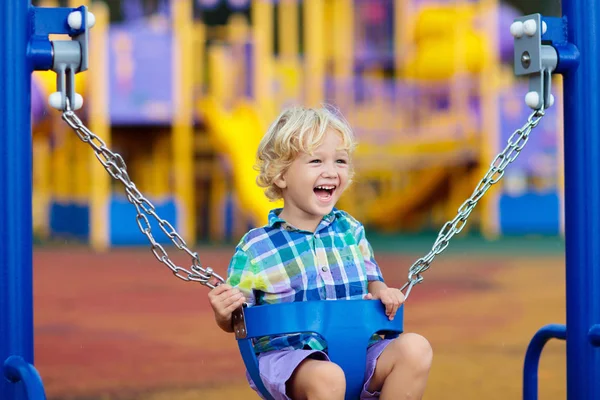 Kind auf Spielplatz. Schaukel Kinder spielen im Freien. — Stockfoto