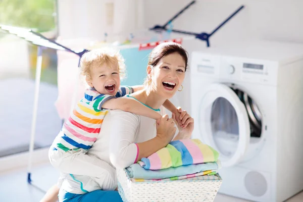 Family in laundry room with washing machine — Stock Photo, Image