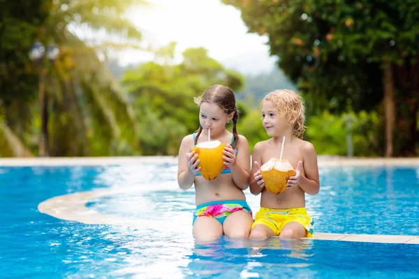 Enfant avec boisson à la noix de coco. Enfants dans la piscine . — Photo