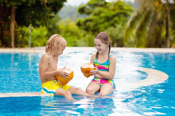 Παιδί με ποτό καρύδας. Παιδιά στην πισίνα. — Φωτογραφία Αρχείου