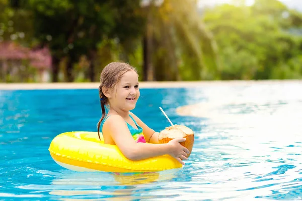 Enfant avec boisson à la noix de coco. Enfants dans la piscine . — Photo