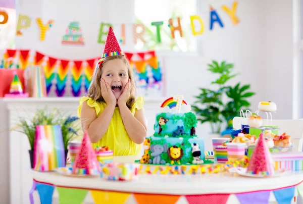 Fiesta de cumpleaños infantil. Los niños soplan vela en la torta . — Foto de Stock