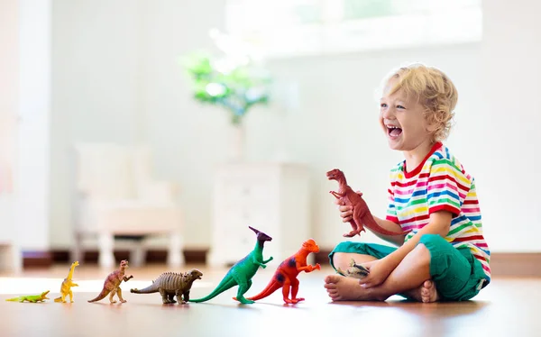 Oyuncak dinozorlar ile oynayan çocuk. Çocuklar oyuncak. — Stok fotoğraf