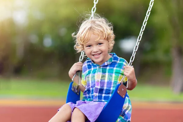 遊び場の子供スイングキッズは屋外で遊ぶ. — ストック写真