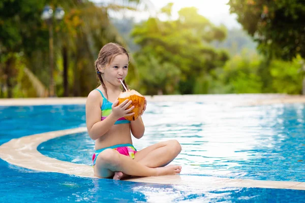 Kind met kokosnoot drankje. Kinderen in het zwembad. — Stockfoto