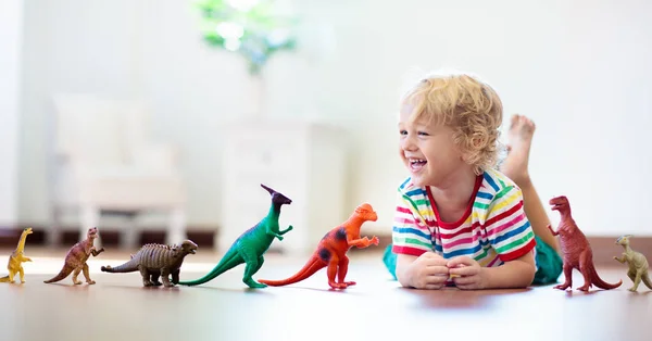 Το παιδί παίζοντας με toy δεινοσαύρων. Παιδικά παιχνίδια. — Φωτογραφία Αρχείου