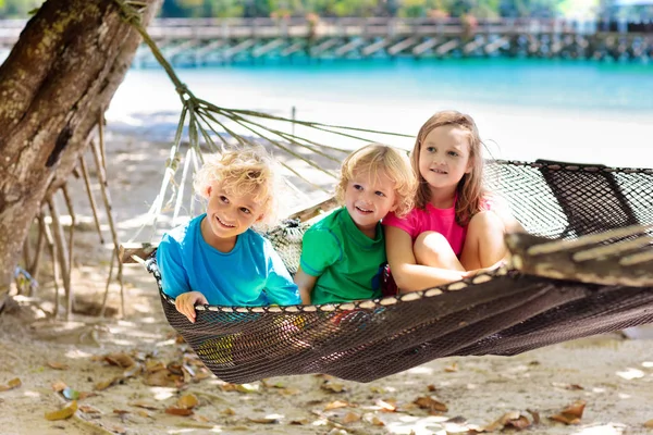 Děti v houpací síti. Děti na tropické pláži. — Stock fotografie