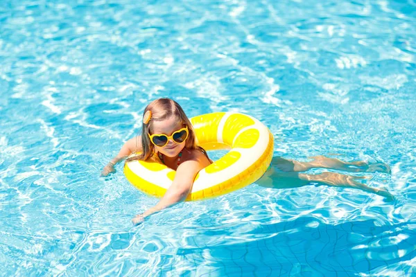 Ребенок в бассейне на кольце игрушки. Дети плавают . — стоковое фото