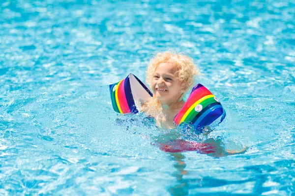 Enfant dans la piscine. Enfant avec brassards flottants . — Photo