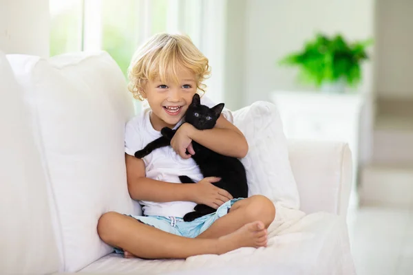 Barn leker med baby katt. Kid och kattunge. — Stockfoto