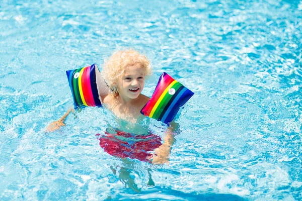 Niño en la piscina. Niño con brazaletes de flotador . — Foto de Stock