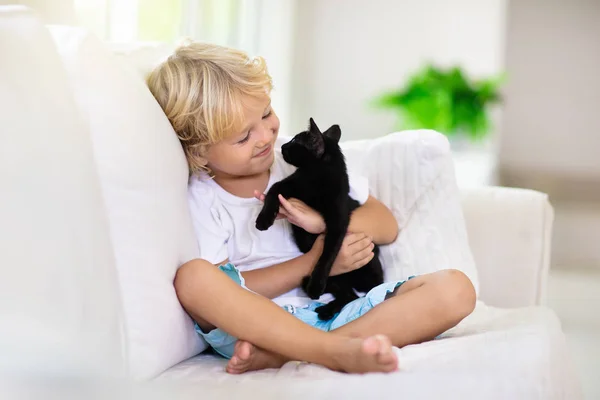 Bebek kediyle oynayan çocuk. Çocuk ve kedi yavrusu. — Stok fotoğraf