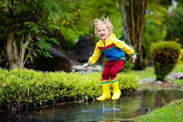 Enfant jouant dans la flaque. Les enfants sautent sous la pluie d'automne — Photo