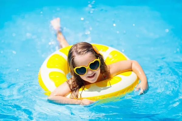 Anak kecil di kolam renang dengan mainan cincin. Anak-anak berenang . — Stok Foto