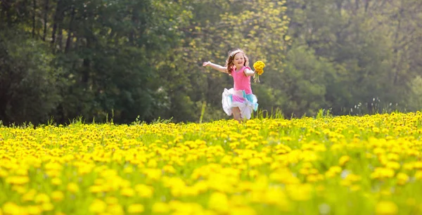 Los niños juegan. Niño en el campo de diente de león. Flor de verano — Foto de Stock