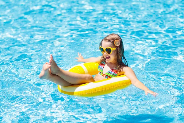 Child in swimming pool on ring toy. Kids swim. Stock Image