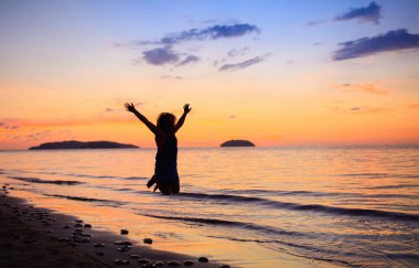 Okyanus plaj üzerinde oynayan çocuk. Gün batımı denizde evlat.