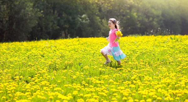 Los niños juegan. Niño en el campo de diente de león. Flor de verano — Foto de Stock