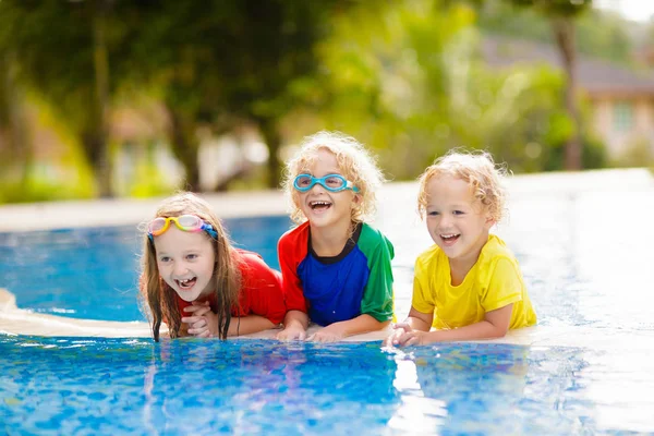 Bambini in piscina. I bambini nuotano. Divertimento in famiglia . — Foto Stock