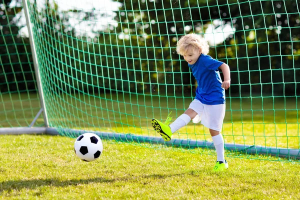 Os miúdos jogam futebol. Criança no campo de futebol . — Fotografia de Stock