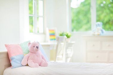 Beyaz güneşli yatak odasında çocuk yatağı