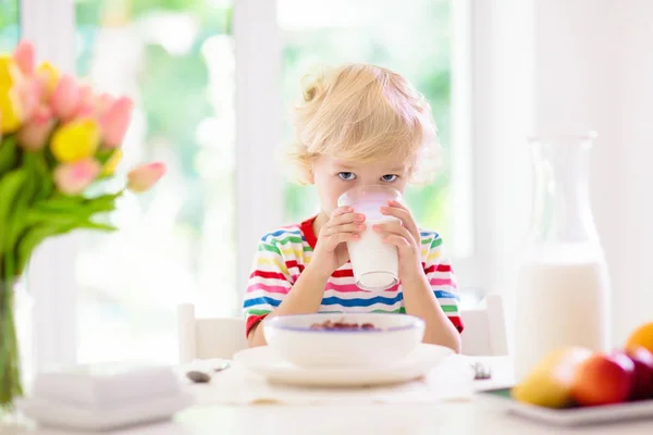 Child eating breakfast. Kid with milk and cereal. — Stock Photo, Image