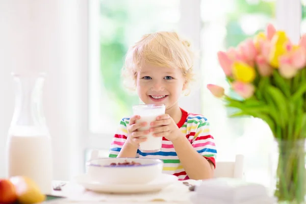 Çocuk kahvaltı yapıyor. Süt ve tahıl ile çocuk. — Stok fotoğraf