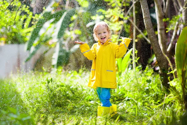 Copilul se joacă în ploaie. Copil cu umbrelă . — Fotografie, imagine de stoc