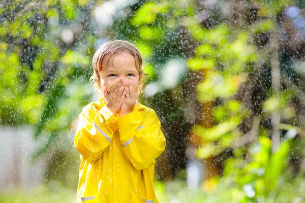 Child playing in the rain. Kid with umbrella. — Stock Photo, Image