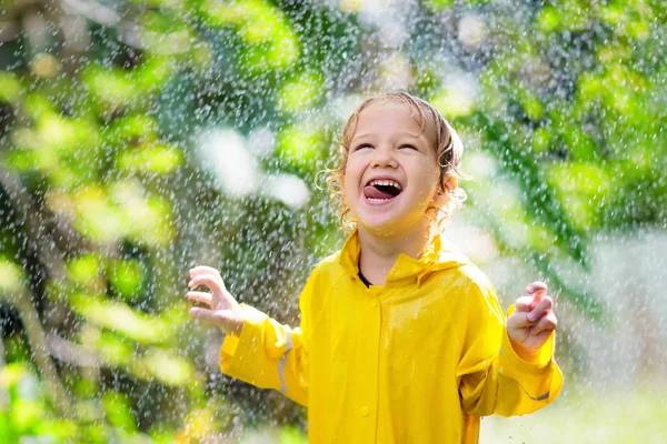 Το παιδί παίζει στη βροχή. Παιδί με ομπρέλα. — Φωτογραφία Αρχείου