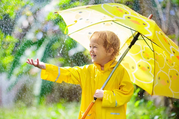 Kind spelen in de regen. Kind met paraplu. — Stockfoto