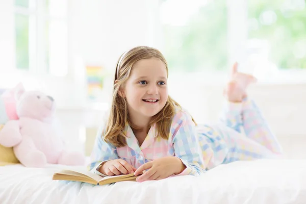 Bambino che legge libro a letto. Bambini letti in camera da letto. — Foto Stock