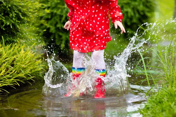 Bambini in pozzanghera in autunno pioggia. usura impermeabile — Foto Stock