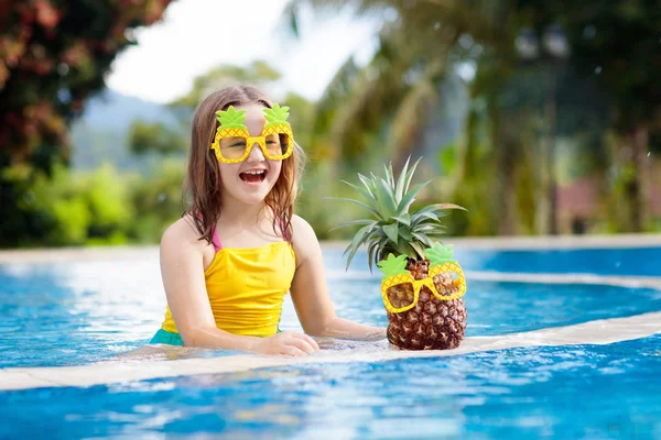 Child with pineapple in swimming pool. Kids swim. — Stock Photo, Image