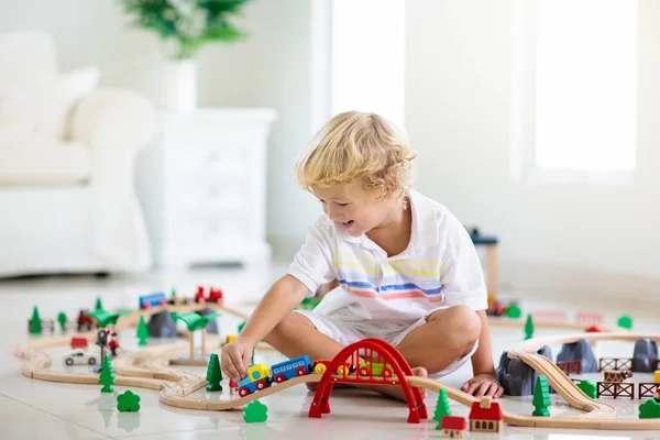 I bambini giocano ferrovia di legno. Bambino con trenino giocattolo . — Foto Stock