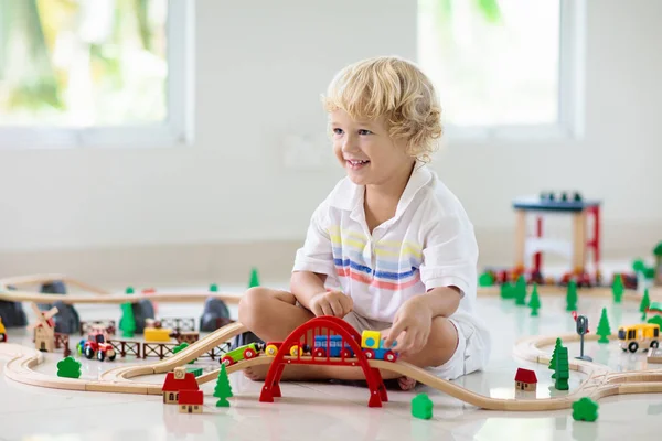 Los niños juegan al tren de madera. Niño con tren de juguete . —  Fotos de Stock