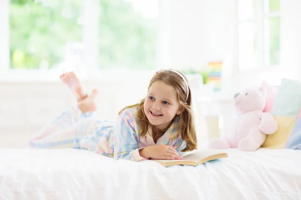 Livro de leitura infantil na cama. Crianças lêem no quarto. — Fotografia de Stock